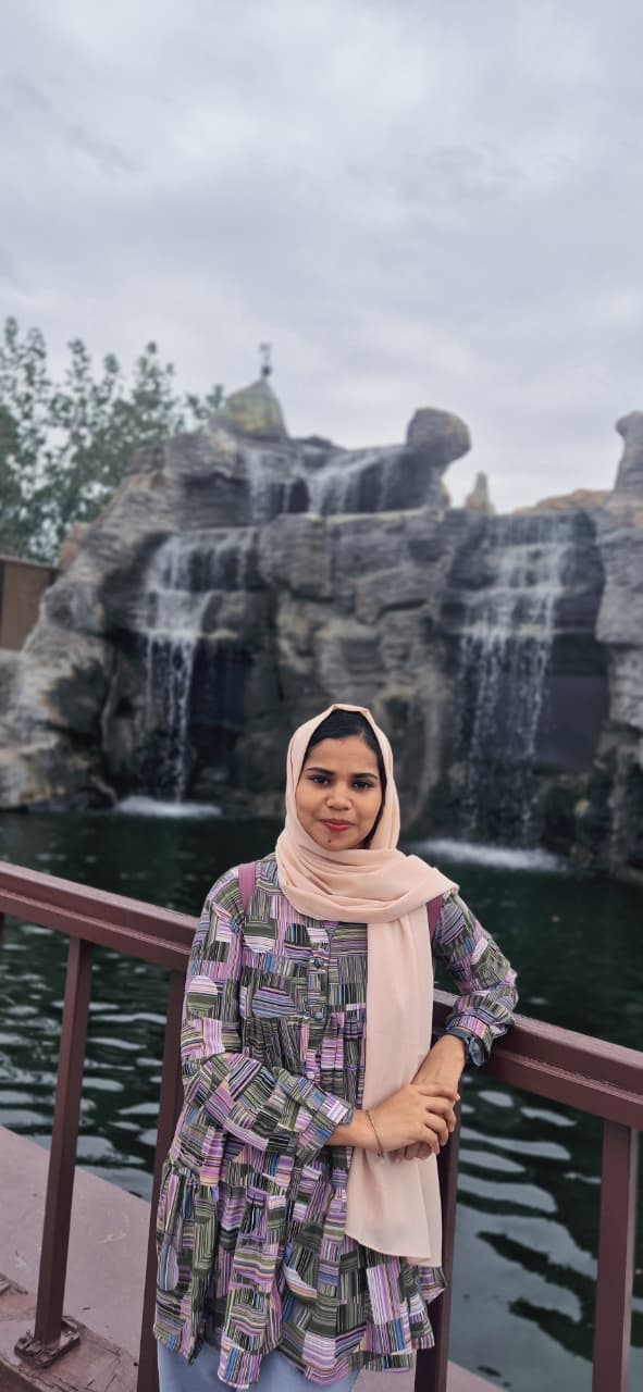 Thasneem A standing by a waterfall